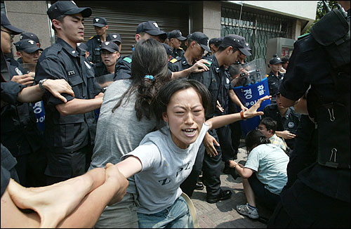 수십명의 경찰들이 삼엄한 경비를 서고 있는 일본문화원 정문에서 대학생들이 건물 진입을 시도하고 있다. 그러나 이들은 곧 경찰들에 의해 전원 연행되어 호송버스에 실려졌다. 